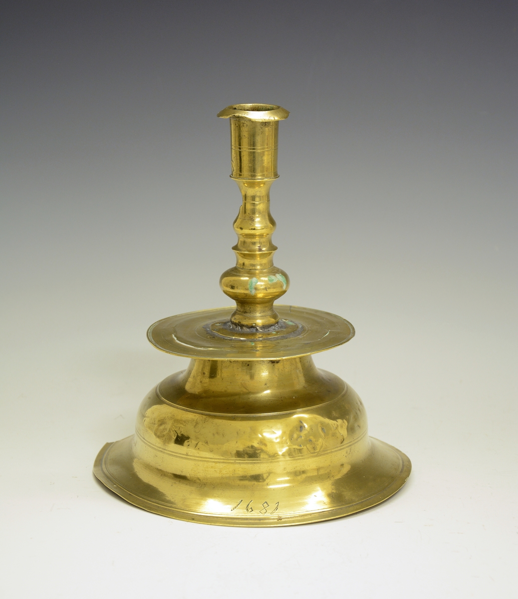 Alterstake av messing. Type omtrent som Wallem fig. 85-86. (Har pipen hørt til en annen stake?). Årstall 1681 (falskt, rimeligvis hugget av sælgeren. (R. Berge)).