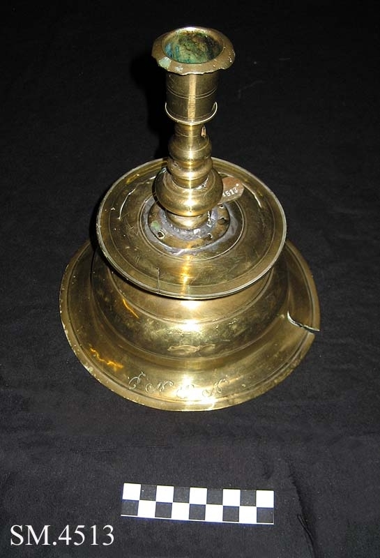 Alterstake av messing. Type omtrent som Wallem fig. 85-86. (Har pipen hørt til en annen stake?). Årstall 1681 (falskt, rimeligvis hugget av sælgeren. (R. Berge)).