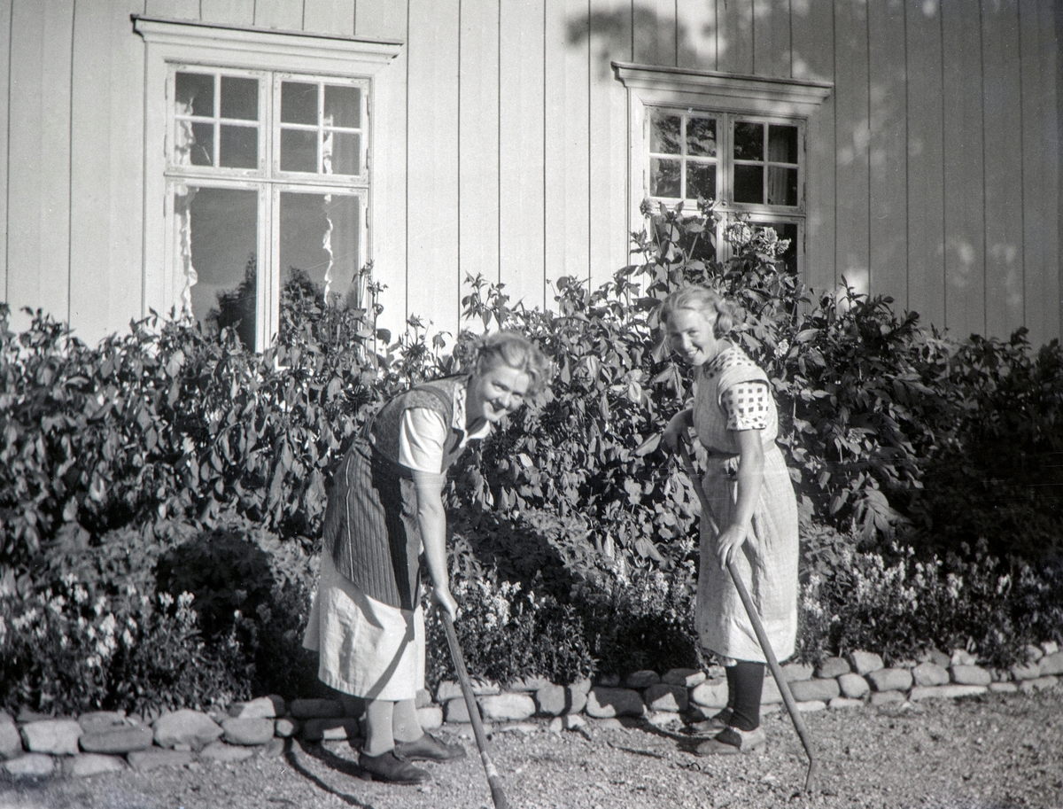 Hagearbeid på Nordre Ottestadi Stange. er rakes det i grusgangen. tv Andrea Margrethe Glærum (1914-1993), født Gjestvang, og  Ella Holt, senere gift Ella Nerhagen. Bilde er tatt midt på 1930-tallet.