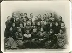 Gruppbild med 32 flickor. En skolklass?