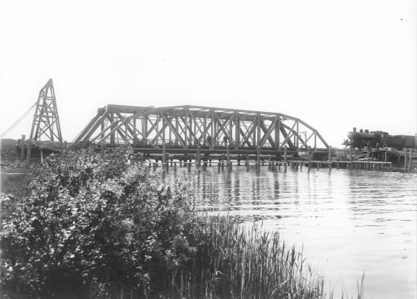 Järnvägslinjen Västkustbanan. Ett ånglok är på väg över järnvägsbron över Viskan i Åskloster.
