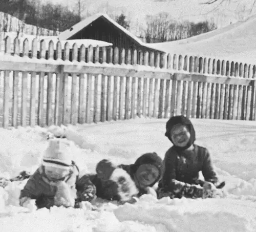 Gammelt foto av barn som leker i snøen.