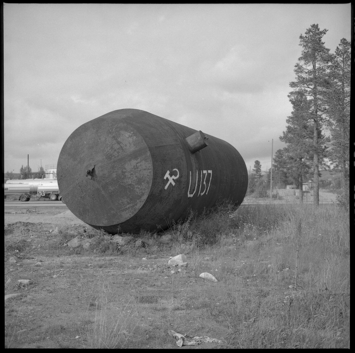 Bilden föreställer en stor ståltank som är märkt med U-137 och Sovjetunionens stadsvapen. Bilden är tagen längs vägen mellan Gällivare och Malmberget.