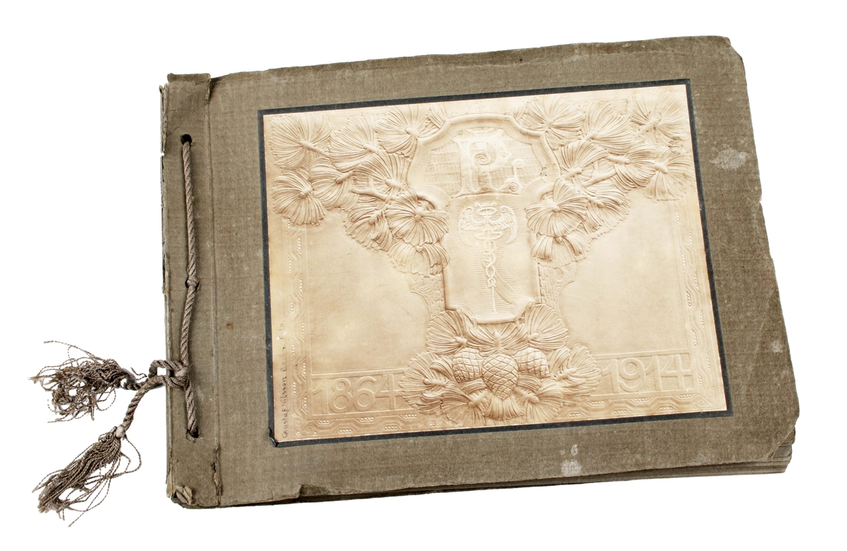 Fotoalbum av grå papp. Bladen bundna med grått snöre. Framsidan med årtalen "1864-1914, initialerna "PL", köpmannaemblem omramat av tallkvistar och kottar". 2 sidor med text angående Pehr Larsons 50-årsdag. 10 sidor med fotografier av Pehr Larson och uppvaktande tjänstemän vid Erikson & Larson.

Texten av John Hedaeus.
Foton av Gustaf Nilsson.

Funktion: 50-årsuppvaktning