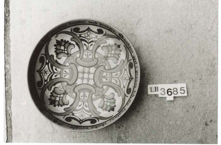 Dreia trebolle med skorne og måla roser på utsida, måla roser og tekst inni bollen.. Tekst skore inn under botn ØV 20-10 1955. Påmåla bollerim på usida av kanten øverts: "Talen til mor di tak du i mot og gjev paa ordi gaum. Daa skal heider og heppe deg fylgje, naar moders ord du minnest. ( Eddakvæde.)" Bollerim inni bollen: "Der tykkjest meg vent aa vera, der drosine dansar med drengjo. Gaukjen gjel i grønan lid, og fuglane skaka venjo."