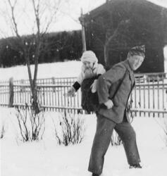 Mann med lita jente på ryggen