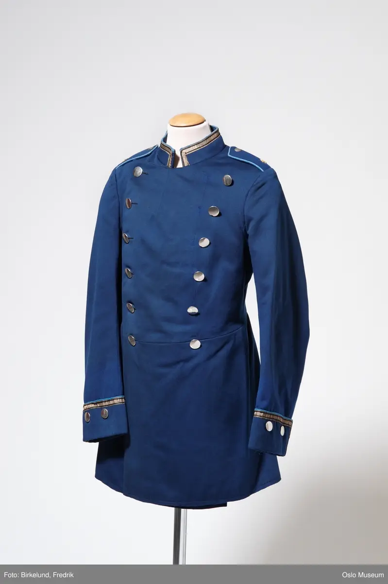 Uniformsjakke, blå med sølv og lyseblå striper. Brukt som kostyme ved Det Norske Teater.