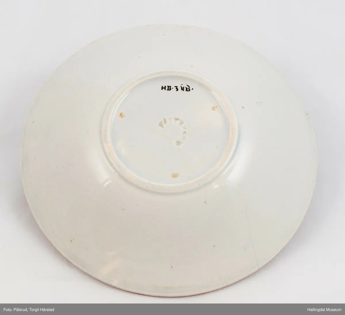 a) Kopp: Stentøy, hvit, liten. Markert fotring. Siden svunget. Utv. polygongal, dekorert med 2 store trekantede blomster i blått og rødt. Mellom dem 6 røde og grønne blad.
b) Skål: Stentøy, hvt, rund. Forholdsvis dyp med skrå side. Samme dekor som koppen. R.B.S.