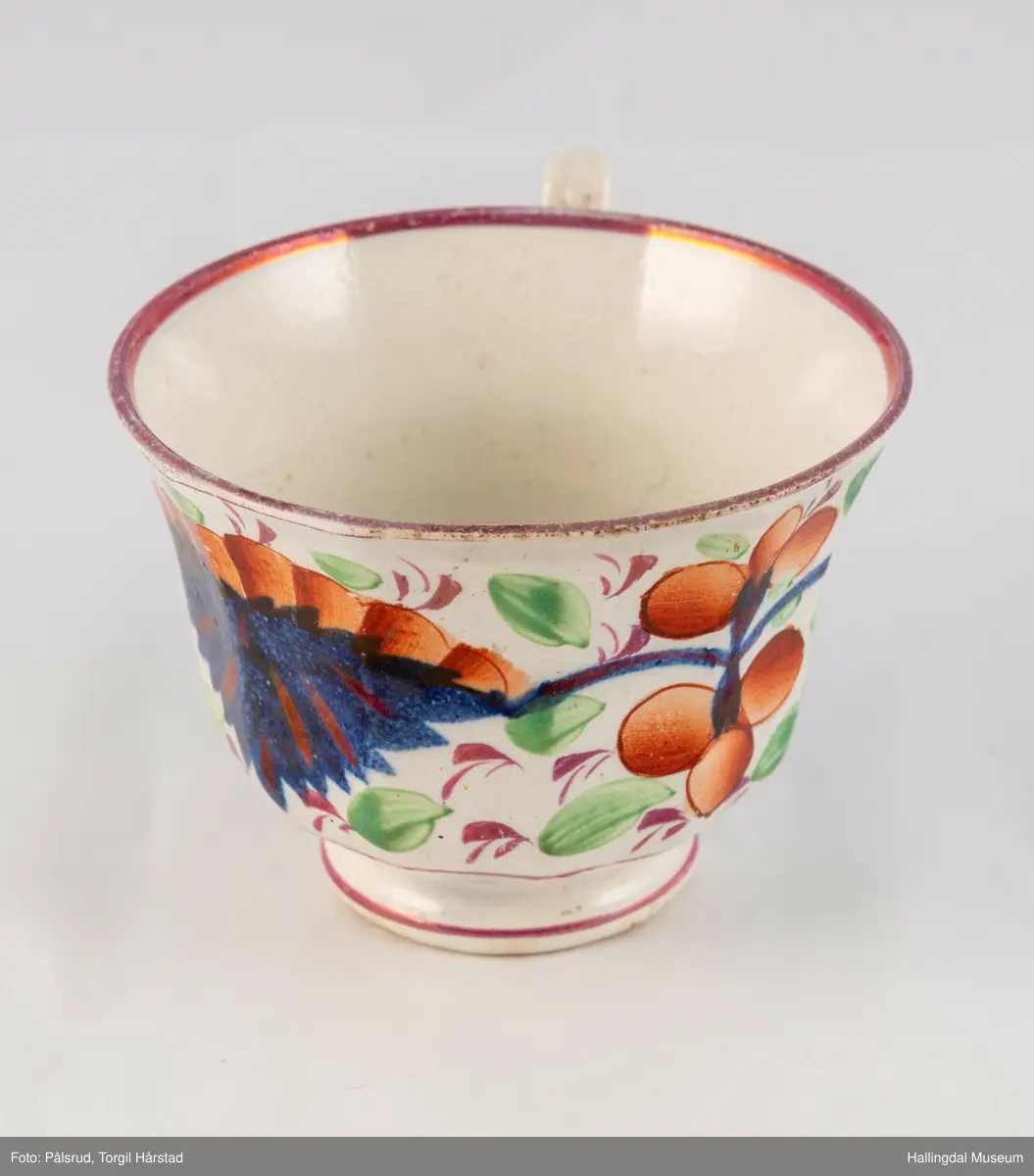 a) Kopp: Stentøy, hvit, liten. Markert fotring. Siden svunget. Utv. polygongal, dekorert med 2 store trekantede blomster i blått og rødt. Mellom dem 6 røde og grønne blad.
b) Skål: Stentøy, hvt, rund. Forholdsvis dyp med skrå side. Samme dekor som koppen. R.B.S.