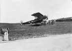 Arbete med uppställt flygplan B 1, Fiat BR, nr 4400, framför Flygkompaniets F-hangar på Malmen omkring 1924-1926. Sex personer vid flygplanet. Tre flygplan FVM Tummeliten i bakgrunden.