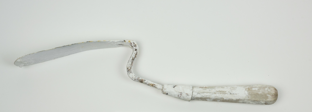 Spatel brukt av Nils Aas til modellering. Den består av et stykke metall formet til en flat, oval form i enden av et trehåndtak. Hele verktøyet er fullt av rester etter gips.