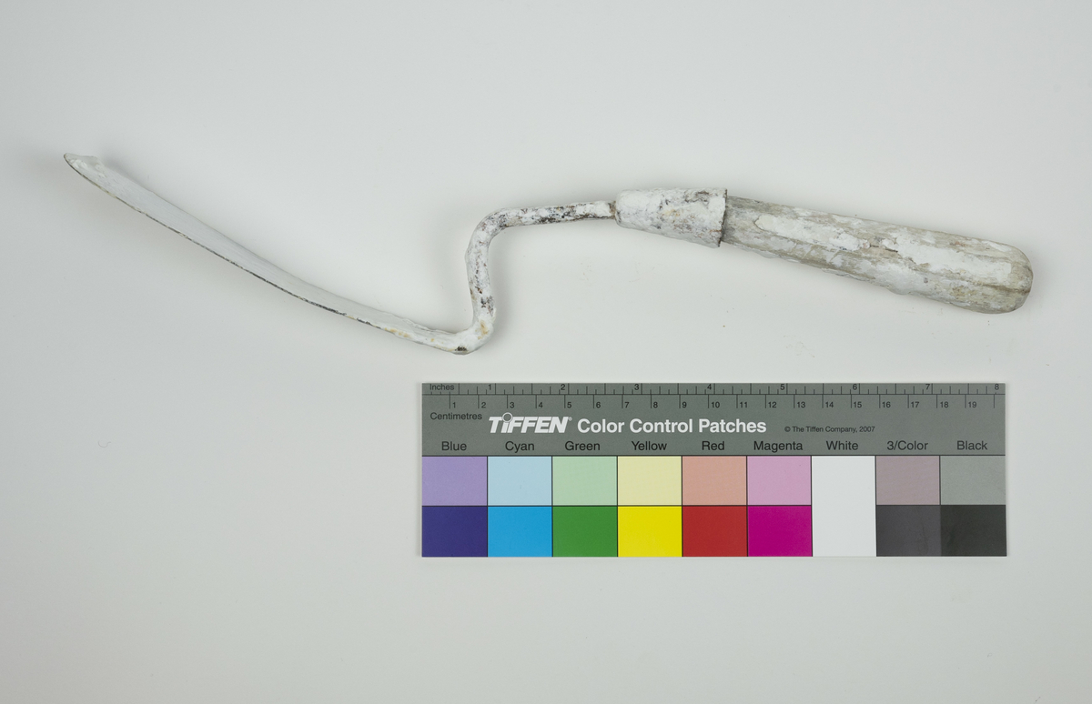 Spatel brukt av Nils Aas til modellering. Den består av et stykke metall formet til en flat, oval form i enden av et trehåndtak. Hele verktøyet er fullt av rester etter gips.