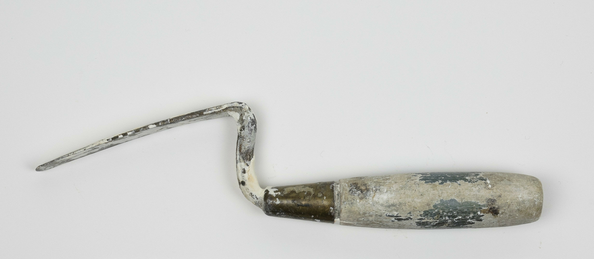 Spatel brukt av Nils Aas til modellering. Den består av et stykke metall formet til en flat, oval form i enden av et trehåndtak. Hele verktøyet er fullt av rester etter gips. Håndtaket var opprinnelig grønt, mesteparten av malingen har derimot flasset av. 