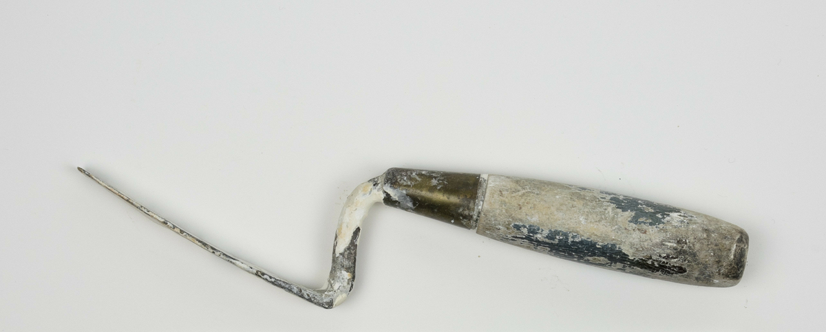 Spatel brukt av Nils Aas til modellering. Den består av et stykke metall formet til en flat, oval form i enden av et trehåndtak. Hele verktøyet er fullt av rester etter gips. Håndtaket var opprinnelig grønt, mesteparten av malingen har derimot flasset av. 