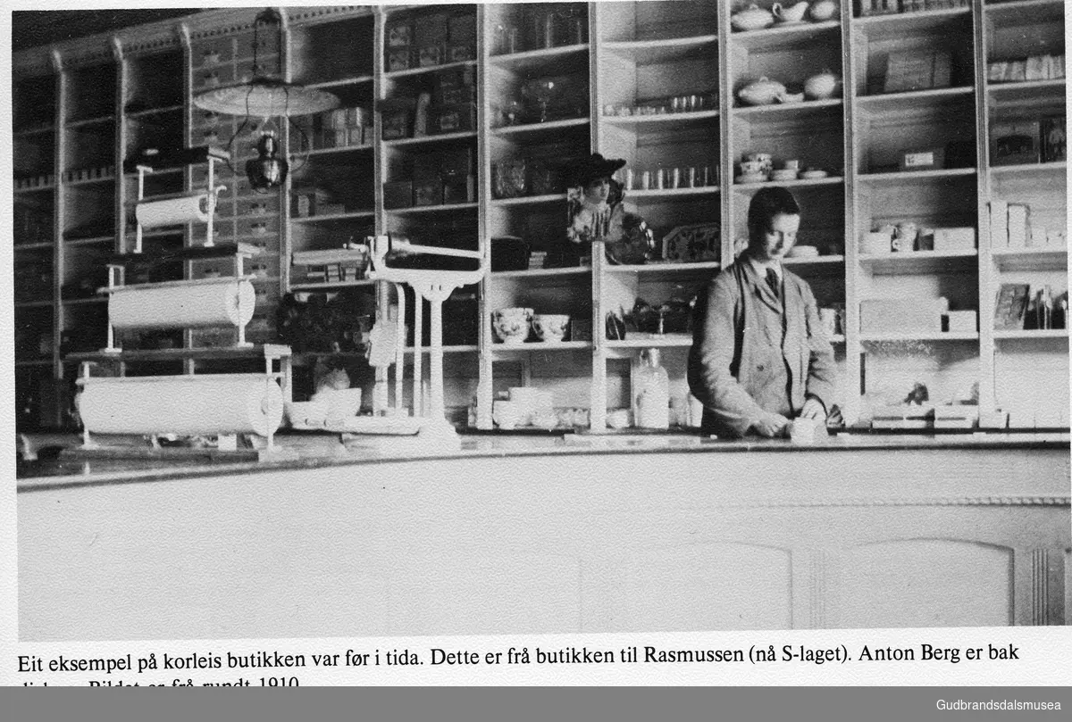 Eit eksempel på korleis butikken var før i tida. Dette er frå butikken til Rasmussen (nå S-laget). Anton Berg er bak disken. Bildet er frå rundt 1910..

Vågåkalenderen 1983, utgjevar: Vågå Kameraklubb