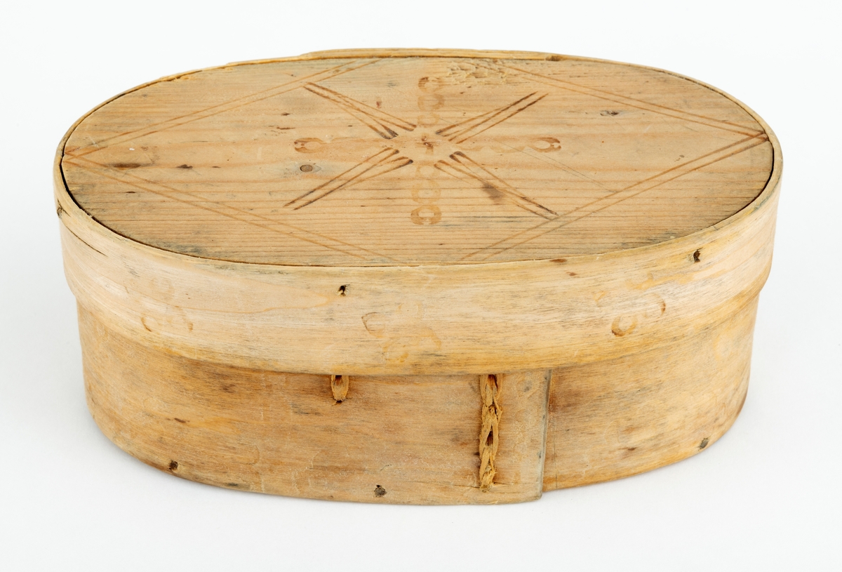 Øskje - en oval beholder med lokk, utført i såkalt sveipeteknikk. Botnplata er et ovalt granbord - 15,1 X 8,0 centimeter. Utenpå denne er det festet sidevegger, lagd av ei cirka 5,5 centimeter bred og 2,6 millimeter tjukk bjørkeplate som antakelig har vært godt fuktet før den ble «brettet» rundt en oval mal og tørket der. Seinere har man beholdt formen ved hjelp av to vertikale sømmer av bjørketeger der hvor ytterendene på veggskia overlapper hverandre. Lokket er lagd på samme måte. Her er plata 15,4 centimeter lang og 8,2 centimeter bred. Rundt denne er det festet en ytterkant, lagd av ei 2,6 centimeter bred og bortimot 2 millimeter tjukk bjørkeskie. Også her er det to vertikale tegersømmer der hvor endene av emnet overlapper hverandre. Sideveggene, både på sjølve beholderen og på lokket, er festet til de ovale granplatene de omslutter ved hjelp av tynne treplugger. Lokket er såpass stort at det omslutter overkanten på beholderen. Oversida av lokket og ytterveggene på sidene er påstemplet dekorelementer ved hjelp av svijern. Innvendig bærer treet preg av å ha vært i nærkontakt med en substans som har vært rik på fettstoffer - muligens skjørost eller pultost.