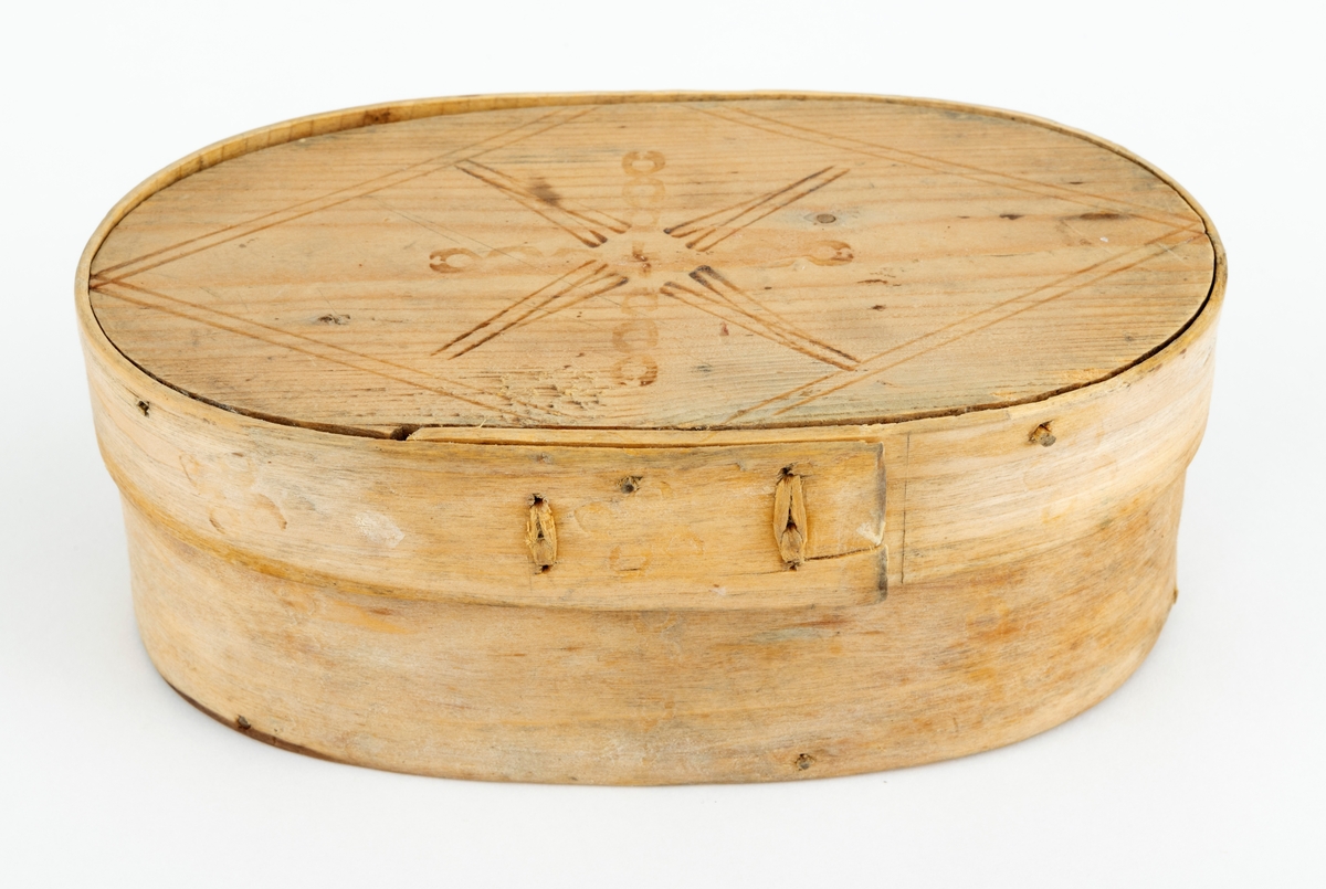 Øskje - en oval beholder med lokk, utført i såkalt sveipeteknikk. Botnplata er et ovalt granbord - 15,1 X 8,0 centimeter. Utenpå denne er det festet sidevegger, lagd av ei cirka 5,5 centimeter bred og 2,6 millimeter tjukk bjørkeplate som antakelig har vært godt fuktet før den ble «brettet» rundt en oval mal og tørket der. Seinere har man beholdt formen ved hjelp av to vertikale sømmer av bjørketeger der hvor ytterendene på veggskia overlapper hverandre. Lokket er lagd på samme måte. Her er plata 15,4 centimeter lang og 8,2 centimeter bred. Rundt denne er det festet en ytterkant, lagd av ei 2,6 centimeter bred og bortimot 2 millimeter tjukk bjørkeskie. Også her er det to vertikale tegersømmer der hvor endene av emnet overlapper hverandre. Sideveggene, både på sjølve beholderen og på lokket, er festet til de ovale granplatene de omslutter ved hjelp av tynne treplugger. Lokket er såpass stort at det omslutter overkanten på beholderen. Oversida av lokket og ytterveggene på sidene er påstemplet dekorelementer ved hjelp av svijern. Innvendig bærer treet preg av å ha vært i nærkontakt med en substans som har vært rik på fettstoffer - muligens skjørost eller pultost.