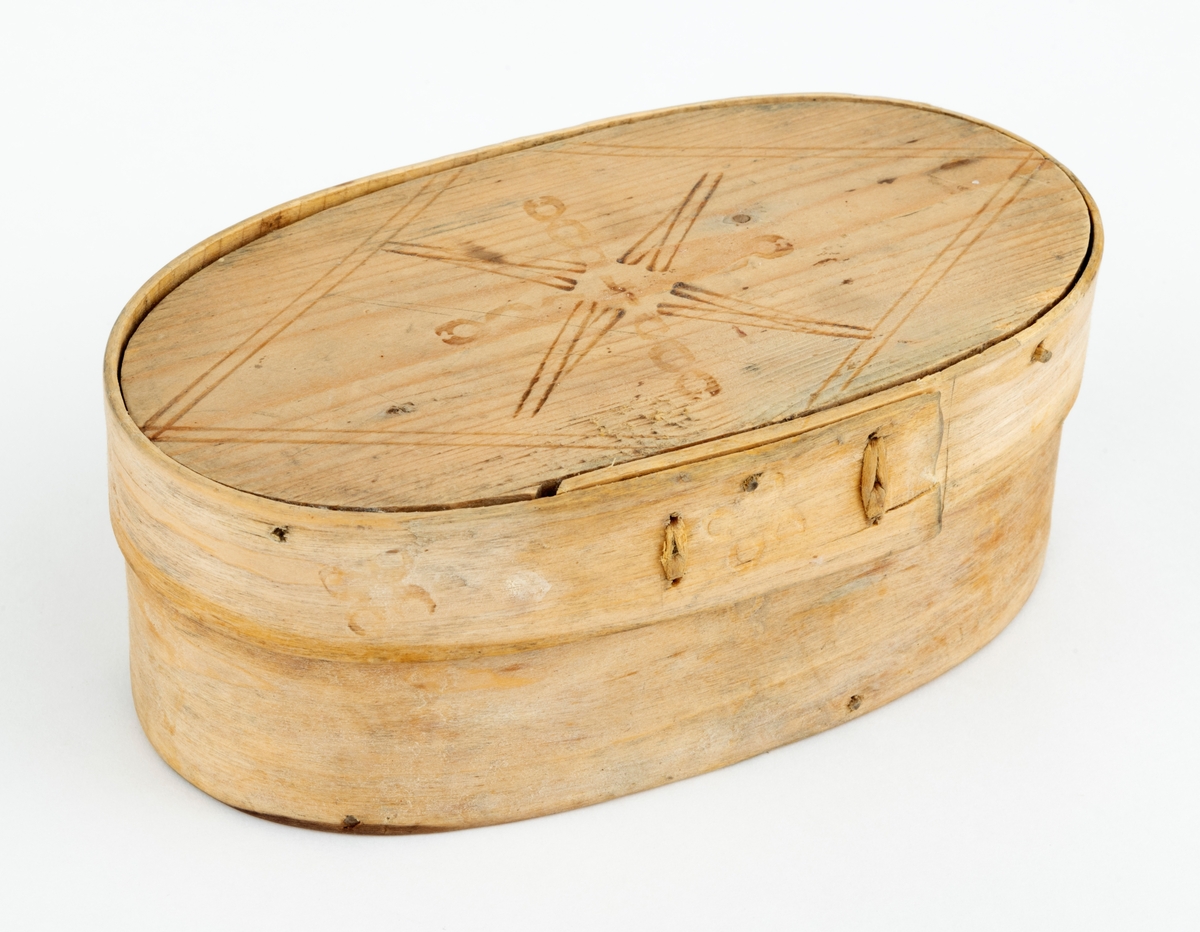 Øskje - en oval beholder med lokk, utført i såkalt sveipeteknikk. Botnplata er et ovalt granbord - 15,1 X 8,0 centimeter. Utenpå denne er det festet sidevegger, lagd av ei cirka 5,5 centimeter bred og 2,6 millimeter tjukk bjørkeplate som antakelig har vært godt fuktet før den ble «brettet» rundt en oval mal og tørket der. Seinere har man beholdt formen ved hjelp av to vertikale sømmer av bjørketeger der hvor ytterendene på veggskia overlapper hverandre. Lokket er lagd på samme måte. Her er plata 15,4 centimeter lang og 8,2 centimeter bred. Rundt denne er det festet en ytterkant, lagd av ei 2,6 centimeter bred og bortimot 2 millimeter tjukk bjørkeskie. Også her er det to vertikale tegersømmer der hvor endene av emnet overlapper hverandre. Sideveggene, både på sjølve beholderen og på lokket, er festet til de ovale granplatene de omslutter ved hjelp av tynne treplugger. Lokket er såpass stort at det omslutter overkanten på beholderen. Oversida av lokket og ytterveggene på sidene er påstemplet dekorelementer ved hjelp av svijern. Innvendig bærer treet preg av å ha vært i nærkontakt med en substans som har vært rik på fettstoffer - muligens skjørost eller pultost.