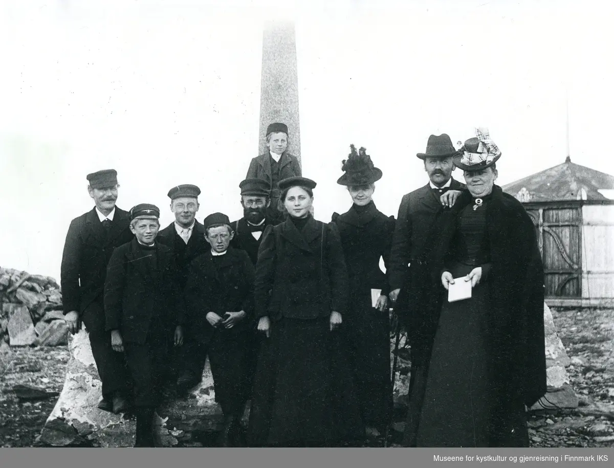 Nordkapp. Turister foran Oscarstøtten. I bakgrunnen Stoppenbrinks champagnepaviljong. 1891-1914.