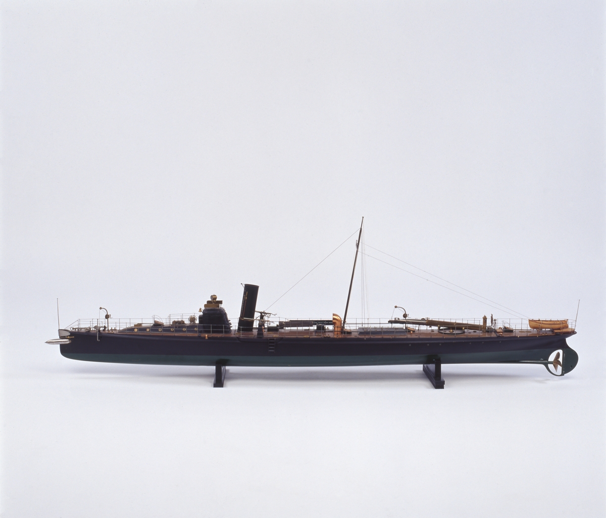 Fartygsmodell lamellbyggd. 

Fullständig däcksinredning, roder, metallpropeller, däckstub av metall med torped av järn, stävtub med torped av järn. 1 skorsten, oval. Riggad mast med vimpel, flaggspel med flagga, gösstake med gös. Fallrepstrappor. Ventilatorer och luckor av koppar. Svartmålad, grön botten, korkfärgat däck. 2 kulsprutor av järn i tamburer. 
Jolle, bordlagd på spant, klink, fullständigt inredd, roder med rorkult och skädda, 4 st åror, 1 båtshake, fernissad. Stativ 2 metallpelare.