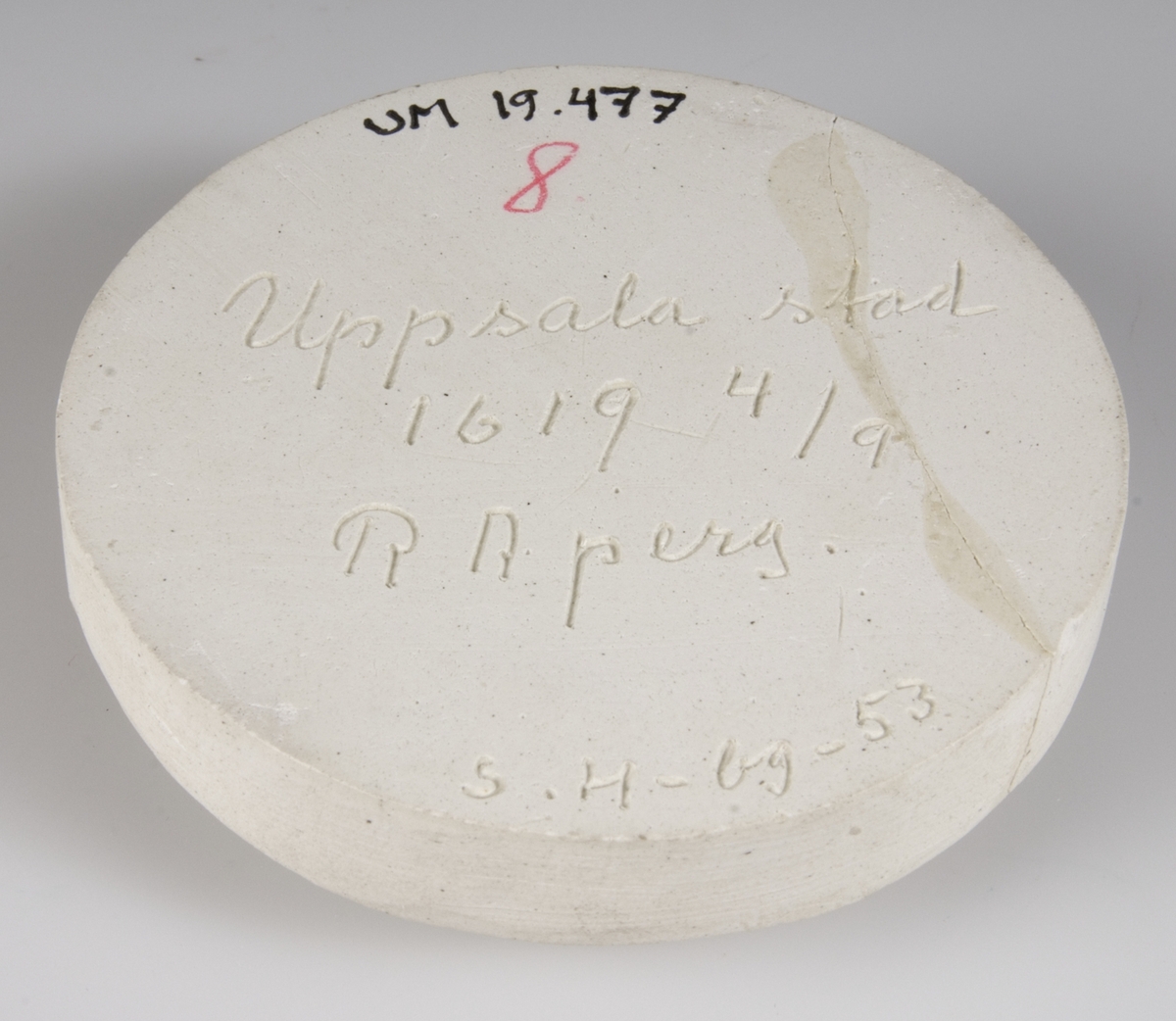 Sigillavtryck av gips av Uppsala stads sigill 1619 4/4 RA. Perg: Grönaktigt på vit rund gipsplatta. Kyrkobyggnad och text. SIGILLUM CIVITATIS YBSALIENSIS.