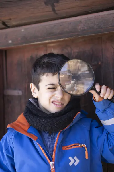 En gutt ser gjennom et forstørrelsesglass