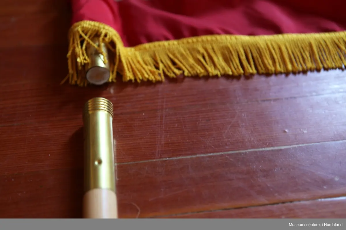 Flagg med stang i to deler, samt en fot. Flagget er rektangulært med 13 røde og hvite horisontale striper, og 50 hvite stjerner på blå bakgrunn i øvre venstre hjørne. Rundt flagget er en gul frynsekant. Flagget er festet til en paradestang av tre med gyllen kule og spyd på toppen. På toppen henger også  en gyllen snor med to dusker som er flettet sammen. Selve stangen kan skrus fra hverandre i to deler.