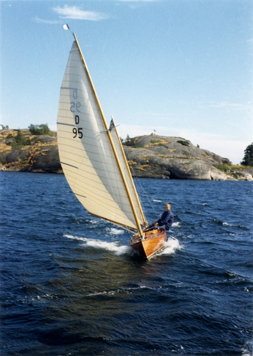 D-kanoten UNDA seglar för babords halsar med Arne Ekström vid rodret.