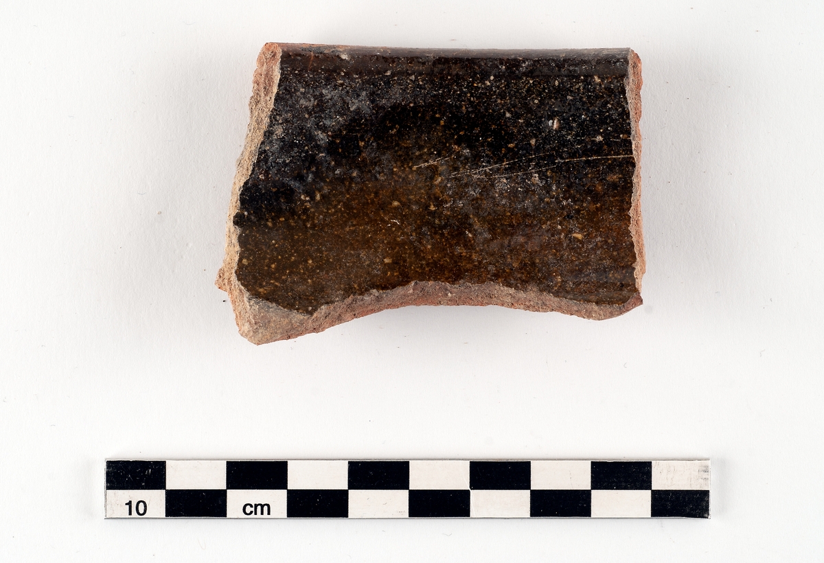 Samling bestående av sex fragment av invändigt glaserat yngre rödgods, gulbrun-mörkbrun glasyrfärg. Tre till fyra kärl, två grytor och en skål kan identifieras. Datering: 1650-1720. Några skärvor ihopklistrade utifrån passning.