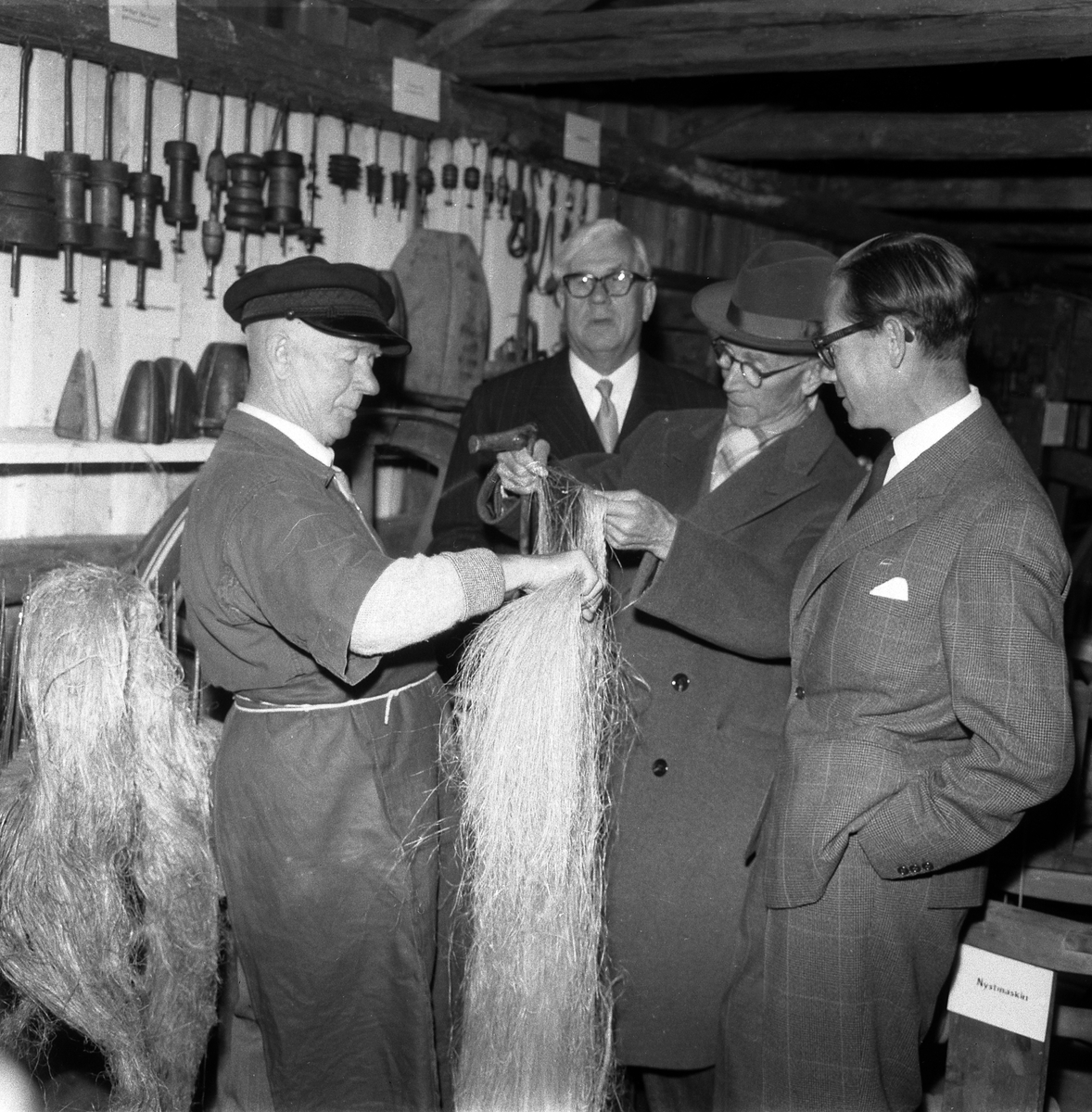Bildserie från invigningen av Wahlbecks repslagerimuseum i Gamla Linköping 1959. Kontorsbyggnaden uppfördes på 1860-talet av byggmästaren Jonas Jonson som hamnkontor och var placerad vid Linköpings hamn. Byggnaden inköptes 1877 av repslagaremästaren Adolf Fredrik Wahlbeck, som lät flytta den till firmans repslageri vid Kanberget där den nyttjades som kontor, butik och magasin. När Wahlbeck 1913 flyttade sin verksamhet till området söder om kyrkogården flyttades även denna byggnad för att 1944 inredas till museum. År 1957 flyttades såväl byggnaden som museet till Gamla Linköping. På bilderna ses bland andra bröderna Gotthard och Ebbe Wahlbeck och den förstnämndes son Olle Wahlbeck.