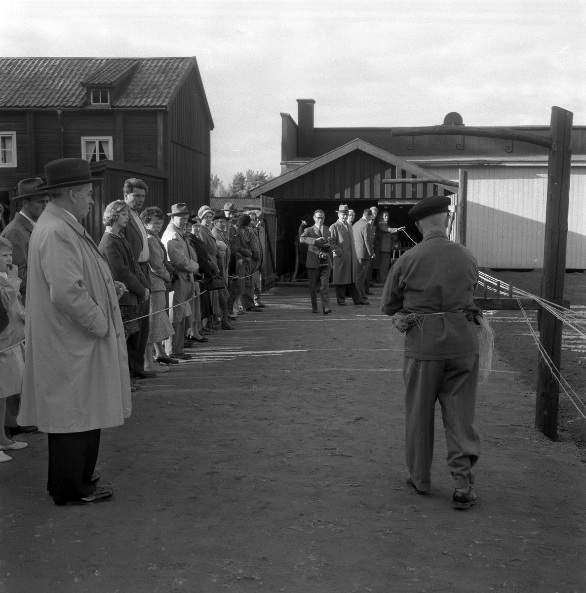 Bildserie från invigningen av Wahlbecks repslagerimuseum i Gamla Linköping 1959. Kontorsbyggnaden uppfördes på 1860-talet av byggmästaren Jonas Jonson som hamnkontor och var placerad vid Linköpings hamn. Byggnaden inköptes 1877 av repslagaremästaren Adolf Fredrik Wahlbeck, som lät flytta den till firmans repslageri vid Kanberget där den nyttjades som kontor, butik och magasin. När Wahlbeck 1913 flyttade sin verksamhet till området söder om kyrkogården flyttades även denna byggnad för att 1944 inredas till museum. År 1957 flyttades såväl byggnaden som museet till Gamla Linköping. På bilderna ses bland andra bröderna Gotthard och Ebbe Wahlbeck och den förstnämndes son Olle Wahlbeck.