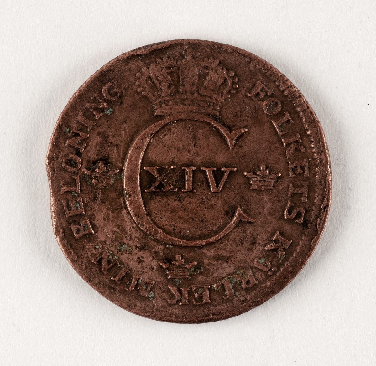 Präglat mynt, av koppar. 1/2 skilling. Åtsida; tre kronor, myntherrens krönta initialer:
C XIV samt omskrift: FOLKETS KÄRLEK MIN BELÖNING. Frånsida: två korslagda pilar samt texten: 1/2 SKILLING 1819. 
Mindre skador.