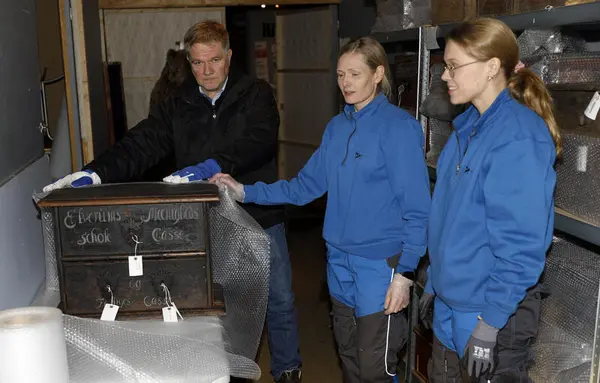 Tre museumsarbeidere avbildet sammen med en kiste fra gjenstandssamlingen på Glomdalsmuseet.