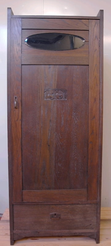 Linneskåp, "äpplet". Jugendstil. Mörkbetsad ek. Delvis fanerad. Svängt överstycke. Lös dörr med ett ovalt glasfönster överst, på baksidan sitter ett papperstryck fastklistrat, motiv blomsterflickor. Mitt på dörren en utskärning i form av två äpplen och fem blad. Mässingsbeslag. Underst en låda med metallbeslag. På insidan av dörren fastklistrad lapp: "Råd vid tvättning av konstsilkeduktyger...". Höjd 193 cm, bredd 71 cm, djup 45 cm, dörrens höjd 140 cm, dörrens bredd 66 cm, dörrens tjocklek 2,5 cm.
