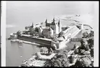 Flygbild över slottet med stadsparken i förgrunden. Det saknas ännu tak på postejerna.