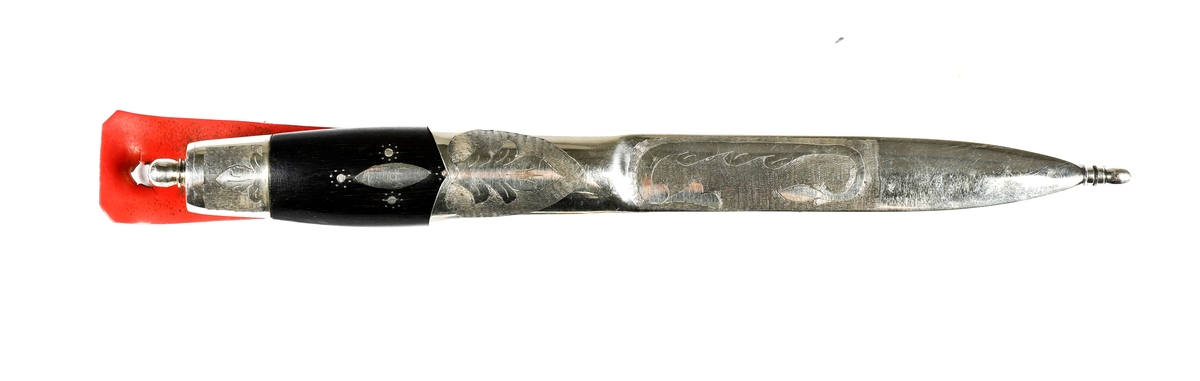 Kniv med slire i nysølv. 

Skaft med holker i nysølv. Endekule i nysølv. Skaft i ibenholt med innfelt dekor i nysølv.  Trambuleringsdekor på endeholker.  
Trambuleringsdekor på slire ( i skaftet).  Slire med  endeholker i nysølv, dekorert med trambuleringer. 
Hengslet hempe i kunstlær.
Bakside av slire påført teksten: H..H 
På knivskaftet står det: Made in Sweden. Laminated steel.