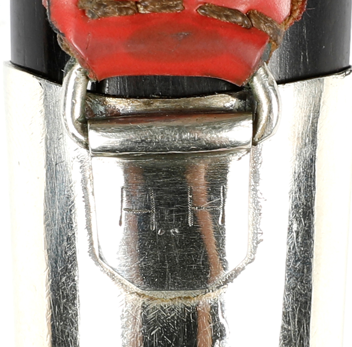 Kniv med slire i nysølv. 

Skaft med holker i nysølv. Endekule i nysølv. Skaft i ibenholt med innfelt dekor i nysølv.  Trambuleringsdekor på endeholker.  
Trambuleringsdekor på slire ( i skaftet).  Slire med  endeholker i nysølv, dekorert med trambuleringer. 
Hengslet hempe i kunstlær.
Bakside av slire påført teksten: H..H 
På knivskaftet står det: Made in Sweden. Laminated steel.