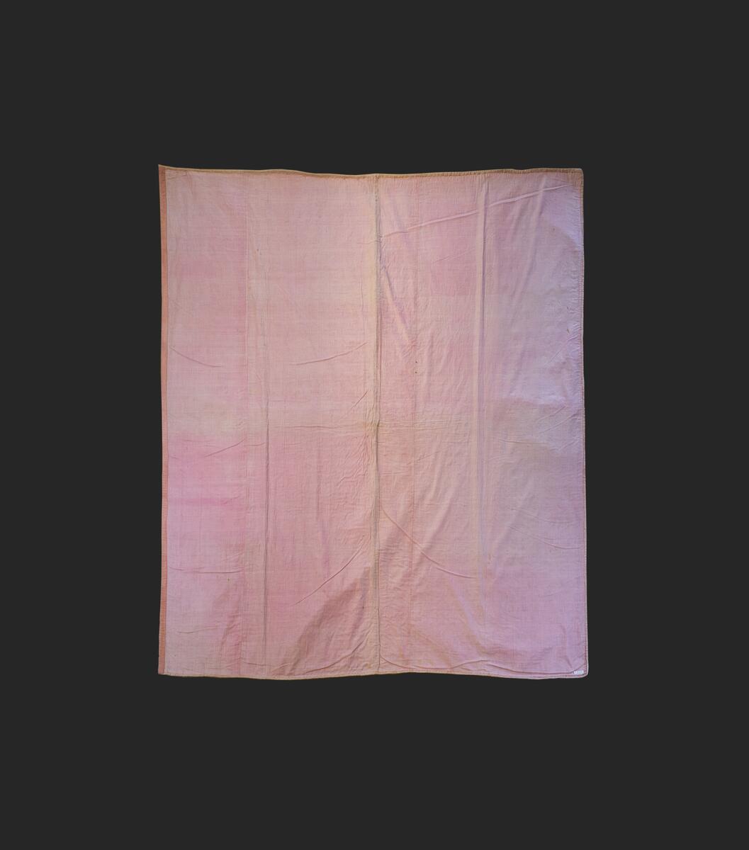 Av rosafärgad sidenatlas med foder av rosa bomullstyg, vadderat och stickat. Består av två broderade längder som ihopsytts. Stickningens mönster är fyra blad som bildar ett rutmönster över hela mittpartiet. Längs långsidorna en bård av flera nyanser i grått och vitt silke i schattérsöm, knutsöm, bottensömmar och stjälkstygn. L. 182 cm, B. 183 cm. Se även: C10594 och C11184 Denna typ av broderade sidentäcken från 1700-talets mitt och senare är ofta omsydda av s.k. "stubbar", vadderade kjolar, då dessa började komma ur bruk. Broderiet är mycket rikt och vittnar om stor skicklighet. Proveniens: Visbyköpmannen Jacob Lindström (1764-1818) hade i sina två äktenskap tre döttrar. När dessa gifte sig skänkte han dem förutom en präktig utstyrsel varsitt brudtäcke. Den andra dottern i ordningen, Anna Margaretha (1807-1891), gift med köpmannen och lantbrukaren Axel Hägg på Katthamra i Östergarn, fick detta täcke. Täcket har efter Anna Margaretha tillhört: 2) Dottern Maria Elisabeth Hägg (1837-1917), Katthamra. 3) Dottern Axelina Charlotta Jacobina (1843-1931), gift Sundell. 4) Axelinas dotter, Ester Kristina (f. 1882), gift Söderman, Katthammarsvik. År 1969 förvärvades det, genom flera sällskaps och fonders donationer, till Fornsalen. Täcket var under lång tid utställt på Fornsalen i utställningen "Gotland för 100 år sedan". Det visades i en dräktmonter tillsammans med de två andra brudtäckena från Jacob Lindströms döttrar. Läs mer: Ulla Melin, "Textila Släktklenoder: Några Anteckningar från Gotlands Hemslöjdsförenings Textilinventering 1944-1948", sid. 88-105, Gotländskt Arkiv 1948-49 & "Historien om tre brudtäcken", Utställningstext, Gotlands Museum
AV SIDEN, FODER AV ROSA BOMULLSTYG. VADDERAT OCH STICKAT. BESTÅR AV 2 BRODERADE LÄNGDER SOM HOPSYTTS. STICKNINGENS MÖNSTER ÄR 4 BLAD, SOM BILDAR ETT RUTMÖNSTER ÖVER HELA MITTPARTIET. LÄNGS LÅNGSIDORNA BÅRD AV FLERA NYANSER I GRÅTEIGT SILKE I SCHATTÉRSÖM, KNUTSÖM, BOTTENSÖMMAR OCH STJÄLKSTYGN. L. 182, BR. 183 CM. INKÖPT FRÅN FRU ESTER SÖDERMAN, KATTHAMMARSVIK,SE GOTL. ARKIV, 1948-49, SID 88.