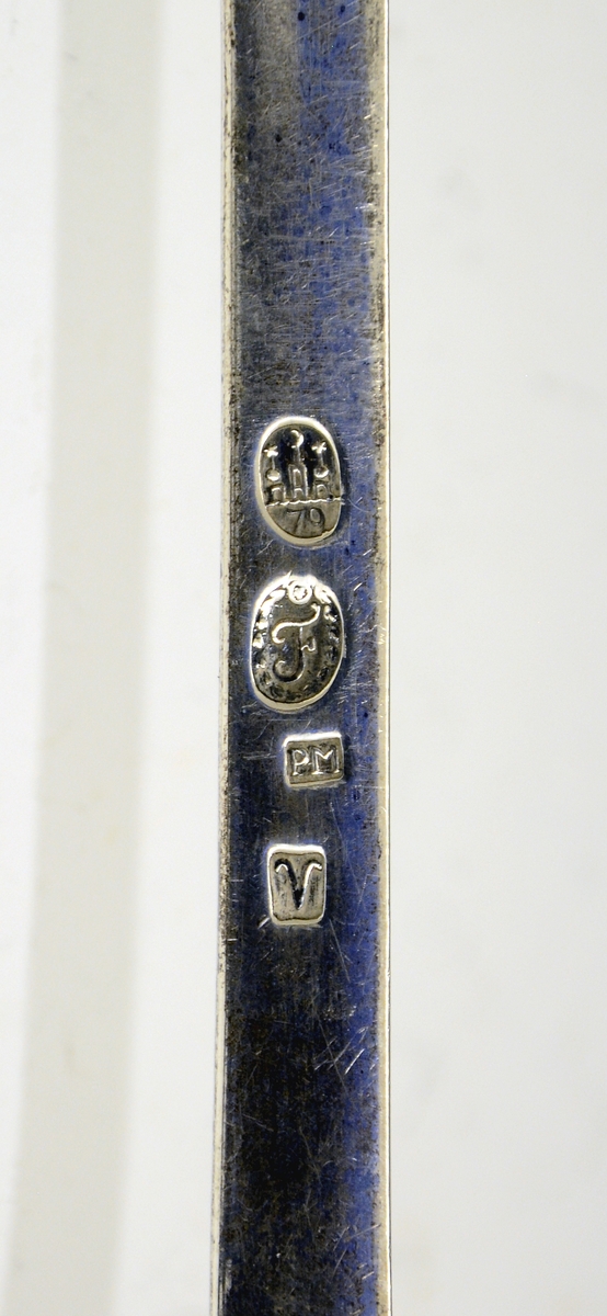 Sølv suppeøse. Dekorert med rokokko-ornamenter. Stemplet med København bystempel og ant. året 1779. (Tre tårn og 79), månedstempel for væren (20.03-20.04), guardeinstempel "F" ant. for Fredrik Fabricius ((1767)1787-1823, København) og mesterstempel PM.