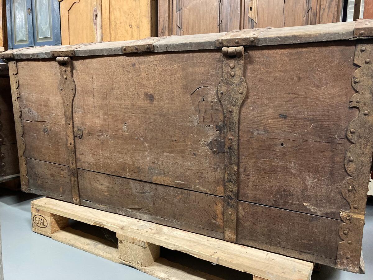 Av ek med rikt ornerade järnbeslag i stiliserade former. L: 157, H: 73, D: 70 cm. Välvt lock med tvärsgående beslag, det mittersta med graverad text mitt på: "PETRUS RONANDER ANNO 1708". Två beslag på baksidan där locket fäster. Hörnbeslag. Tre beslag på framsidan, det mittersta med nyckelskylt, nyckel sitter i låset. Beslag på sidorna samt ringöglor i järn som fungerar som handtag. Inuti locket en delvis bortsliten lapp med texten: "[...]X. 1937 X1. 1938 G. Minnesmärken, Nils Lit[...]". Dåligt skick med slitage, materialbortfall och sprickor. Har tillhört Bankdirektör Gustaf Kolmodin.
AV EK, KOLOSSAL, VÄL BIBEHÅLLEN MED ORNERADE JÄRNBESLAG. I MITTBESLAGET OVANPÅ: "PETRUS RONANDER ANNO 1708". HAR SENAST TILLHÖRT BANKDIREKTÖR GUSTAF KOLMODIN.
