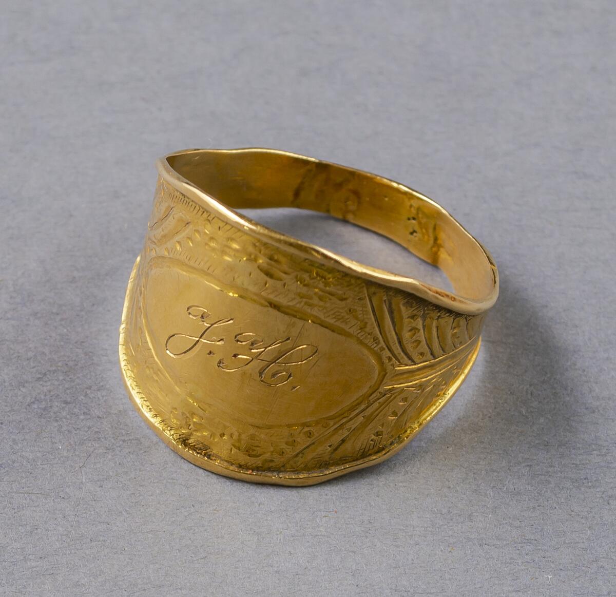 FRÅN PETES, HABLINGBO. GÅVA. . GULD. RING INITIALERNA: J.H. MED CISELERAD ORNAMENTIK RUNT OM. HAR TILLHÖRT JACOB HÄGG, PETES, HABLINGBO. STÄMPEL: 22 K M8 TILLVERKAD 1938.. . ADA BLOCKS BOHAG GÅVA TILL GOTLANDS FORNSAL, ENLIGT TESTAMENTE, 1968.