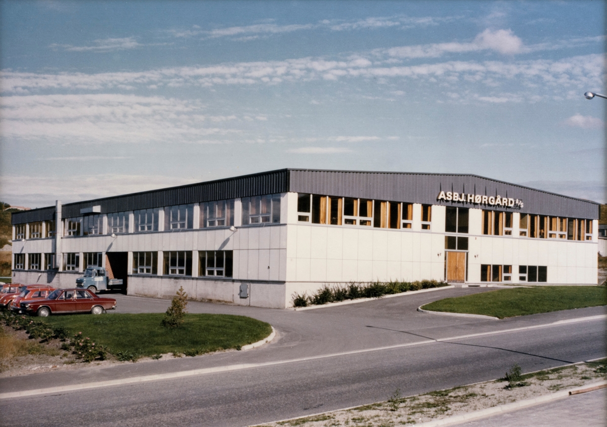 Fotografiet viser fasaden til firmaet Asbjørn Hørgård  A/S' produksjonslokaler i Fossegrenda 36, utenfor Trondheim sentrum.  Produksjonslokalene hadde et areal på 3200 kvadratmeter fordelt på tre etasjer. Lokalene ble innviet 28. mai 1973, og det antas at fotografiet er tatt samme år.  Her ble det produsert laminerte fiskestenger, splitcanestenger, med utgangspunkt i bambus (tonkinbambus) som råemne. Firmaet hadde i flere år produsert forskjellige fiskeredskaper i tillegg til splittkeinstengene, f. eks. sneller og sluker. I lokalene i Fossegrenda 36 var det en egen mekanisk avdeling for produksjon av metallvarer. Firmaets navn, Asbj. Hørgård A/S, ses over vinduene på gavlveggen. (Se blant annet side 24 Hørgårds bok "Sportsfiske som hobby i 65 år", der det fortelles om innvielsen av lokalene.)

[Se referanser og referanser til filer for mer informasjon om hvordan framstillingen av splittkeinstenger foregikk. Se fanen "Opplysninger" for informasjon om Asbjørn Hørgård og hans firma. ]