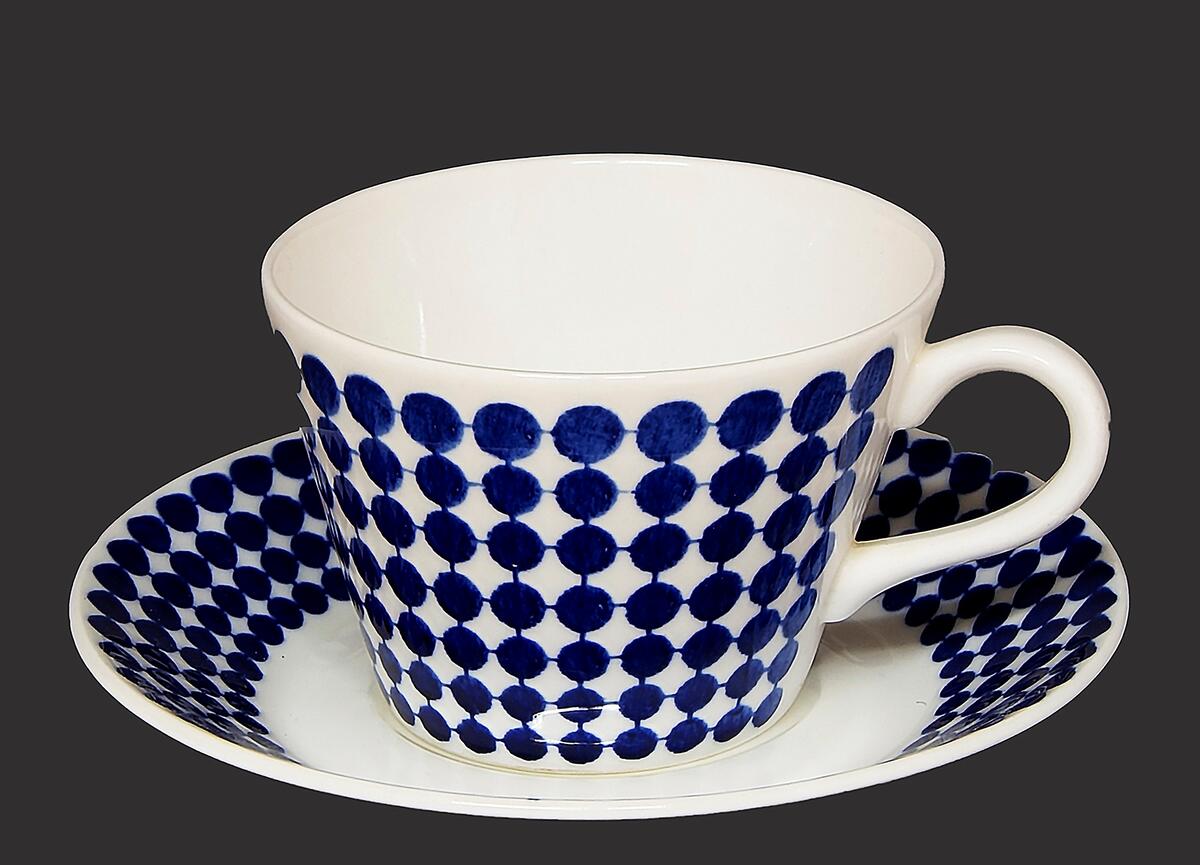 Kaffekopp med fat, vit med blå prickar, gustavsbergs serie adam formgiven av stig lindberg och satt i produktion 1959, på undersidan av både kopp och fat finns firmamärket, ett ankare omgivet av "gustavsberg" på fatet vidare "sweden benporslin adam" skrivet i blått,  på koppen "benporslin adam stig l. Vdn b555 made in sweden" skrivet i grönt, har använts i museets (fornvännernas) uthyrningslägenheter, när fastigheterna såldes tillvaratogs en del husgeråd och möbler och införlivades med samlingarna
nyreg data 001116 li