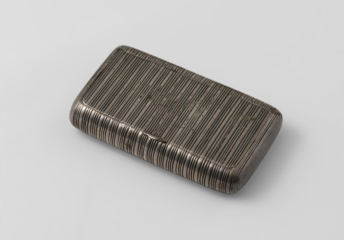 Av silver, fyrsidig form med rundade sidor, räfflad på tvären. Stämplad: J N P N4 (Johan Niklas Palm, 1843). 6,2 x 3,5, höjd 1 cm