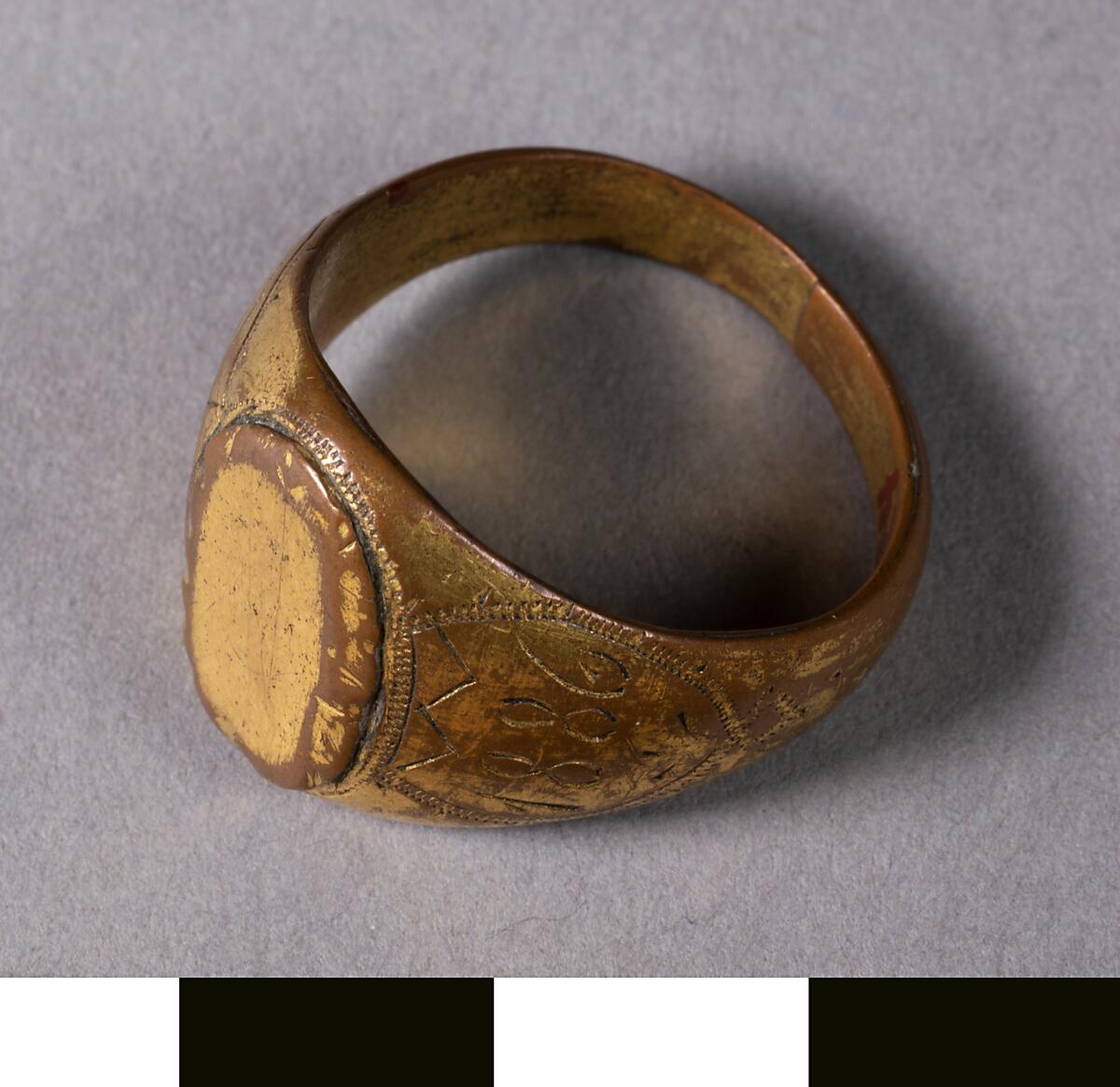 Klackring av gul metall, årtalen 1702 (9) och 1886.  Ringen ligger i en svart ask med texten "Neuheit, Feine Bÿouterie".
Av gul metall, årtalen 1709, 1886, ingraverade.