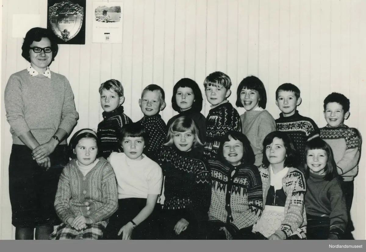 Elever og lærer ved Saursfjord skole. Lærer Elin Elvegaard. Elevene i bakerste rekke fra venstre: Viggo Jacobsen, Herulf Abrahamsen, Marianne Steffensen, Willy Johannessen, Sylvia Pettersen, Erling Saur og Viggo Olsen.  Foran fra venstre: Linda Larsen, Iren Hansen, Ann Venke Johansen, Ragnhild Pedersen, Ann-Karin Willumsen og Tove Hansen.