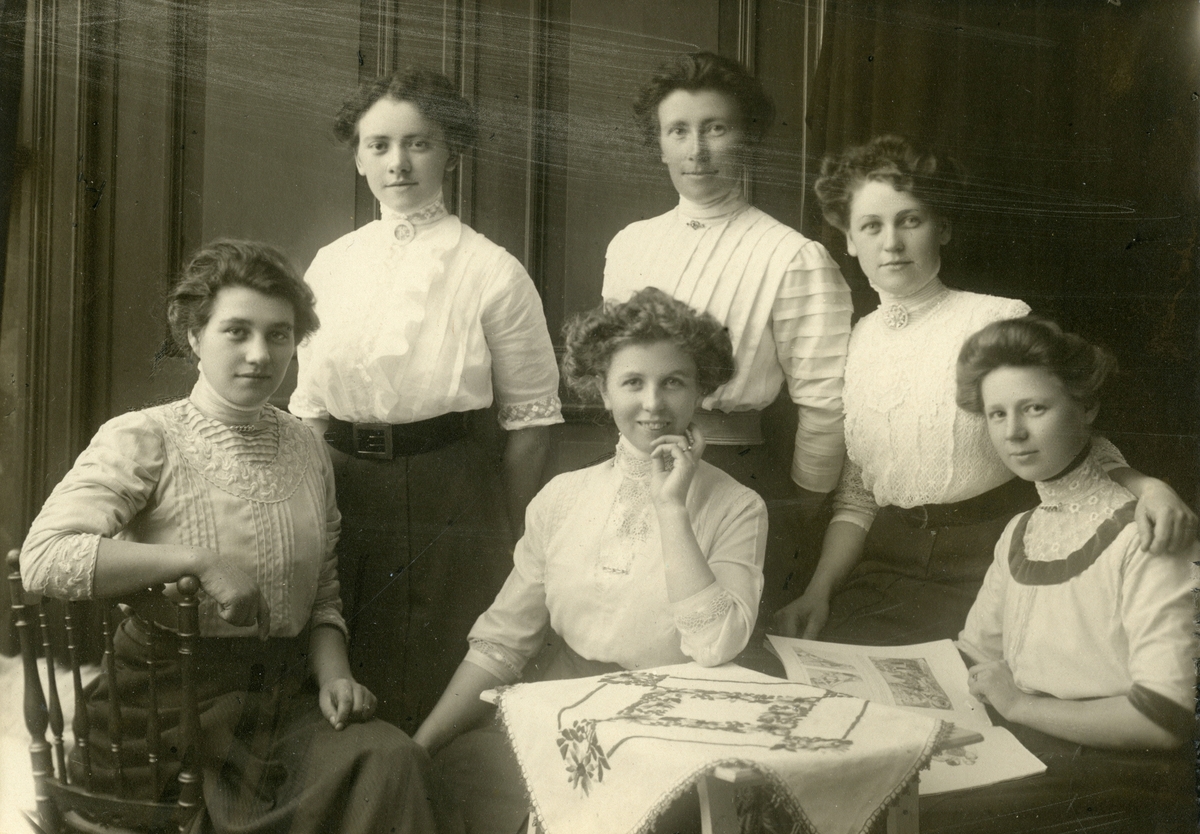 Gruppeportrett av sydvest-syersker ved Helly Hansen AS i Moss ca.  1906.  
Foran fra venstre: 
Alvilde Reier (reist til USA i 1911), Frida Andresen, gift Andersen (var 70 år i juni 1958), Karen Andresen gift Pettersen Broch. 

Bak fra venstre: 
Sigrid Arvesen gift Evensen (mor til Odd Evensen), Konstanse WIlhelmsen. Hedvig Berg gift Berglund.