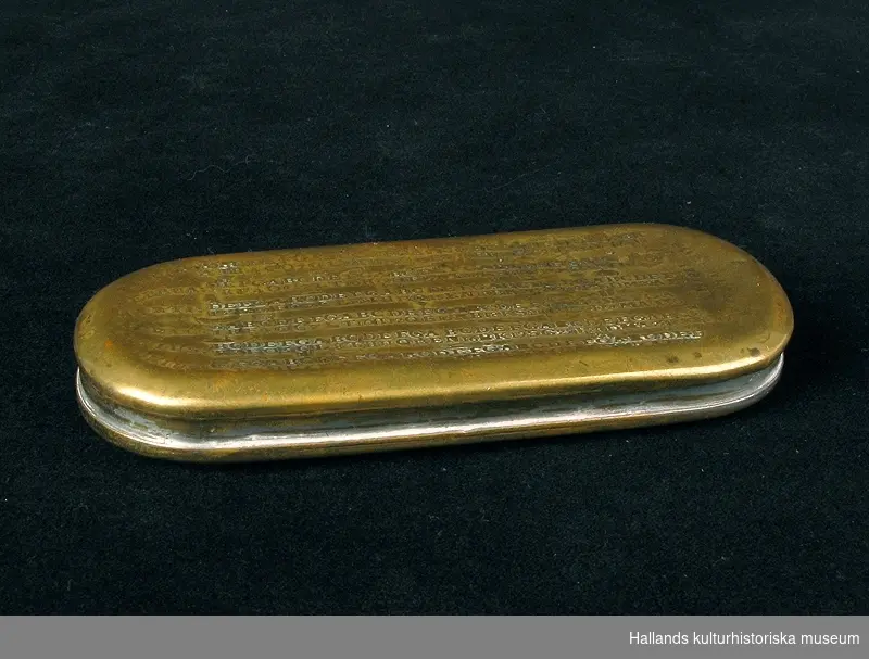 Kalenderdosa. Rektangulär med rundade hörn. På locket en kalender med bokstäver och symboler i upphöjd relief. Höger: "FORSWENSKAD 1787 4/1". Vänster: "JANUAR: FEBRUA: MARTI: APRIL: MAIUS: JUNIUS:" Mittbak på dosans kant finns ett hål.