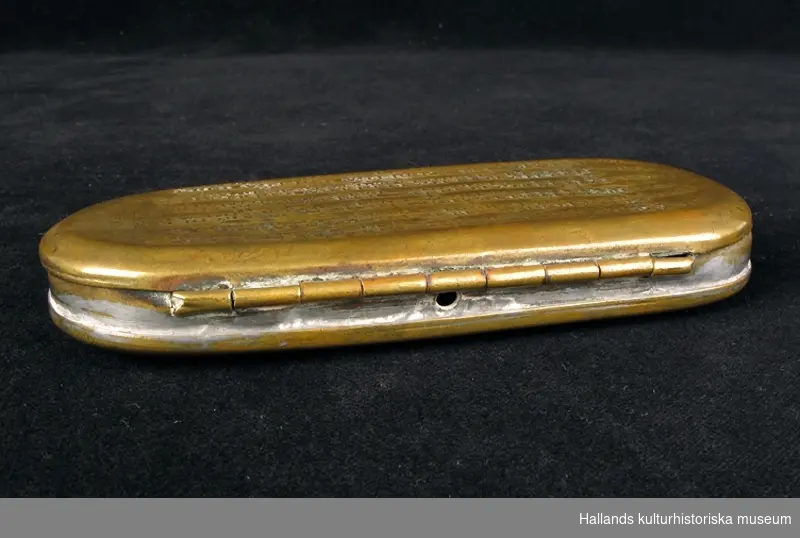 Kalenderdosa. Rektangulär med rundade hörn. På locket en kalender med bokstäver och symboler i upphöjd relief. Höger: "FORSWENSKAD 1787 4/1". Vänster: "JANUAR: FEBRUA: MARTI: APRIL: MAIUS: JUNIUS:" Mittbak på dosans kant finns ett hål.