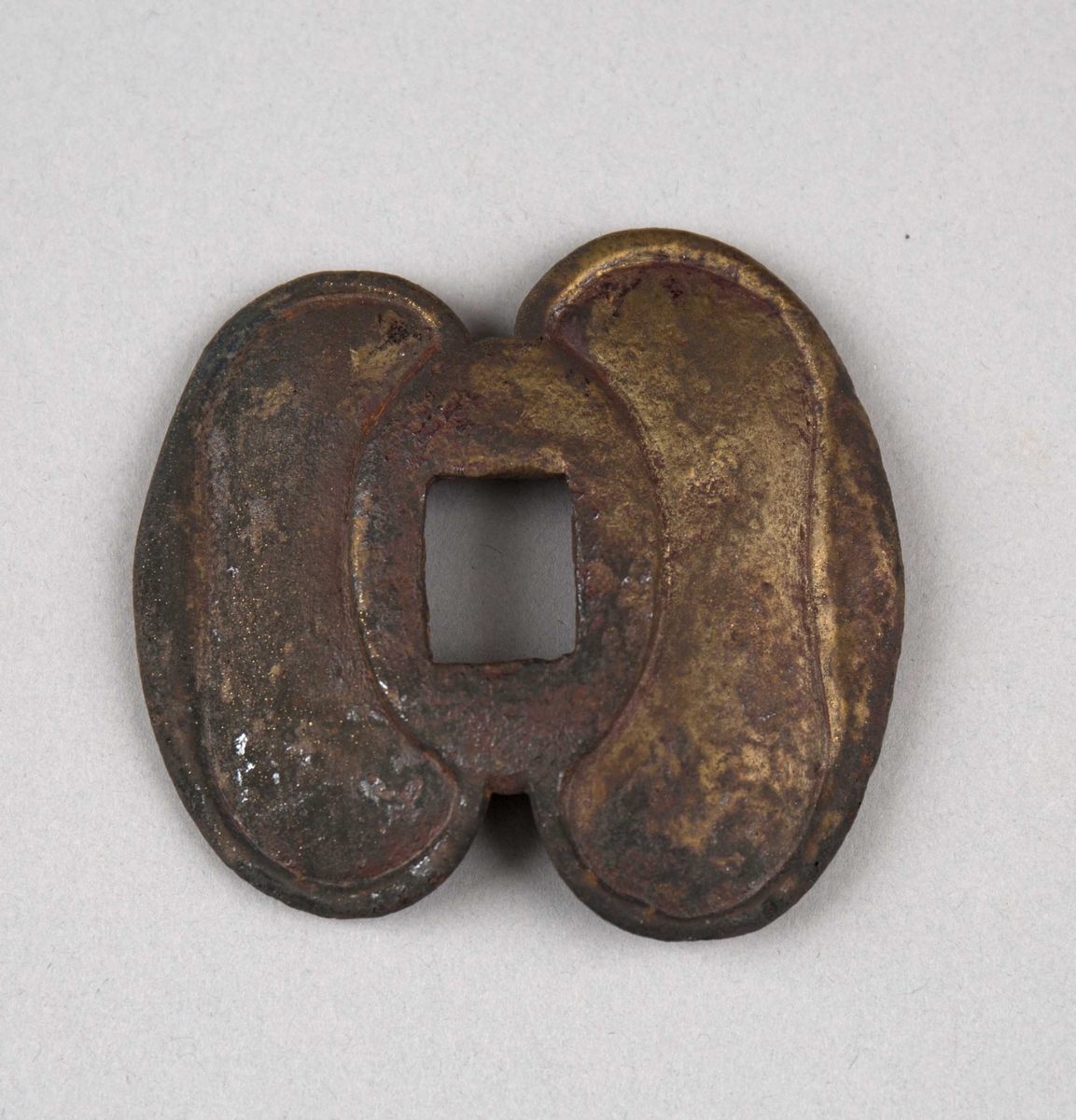 Håndbeskyttelse (pareplate) fra et sverd funnet ved skipet AKERENDAM, kjent som Rundefunnet fra Runde på Sunnmøre. Den er formet som to sammensatte ovaler med et rektangulært hull i midten.